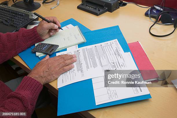 mature man preparing tax forms, close-up - burocrazia foto e immagini stock