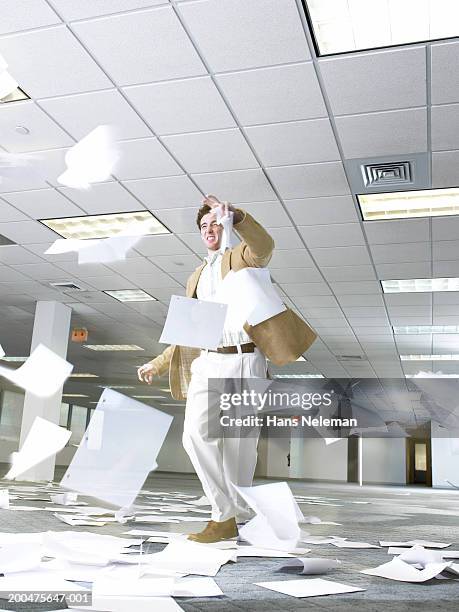 businessman walking through windblown paperwork - paper blowing stock pictures, royalty-free photos & images