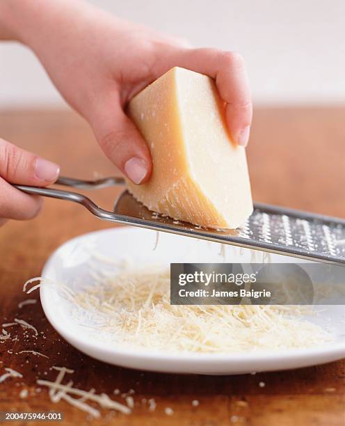 person grating parmesan cheese, close-up - metal grate fotografías e imágenes de stock