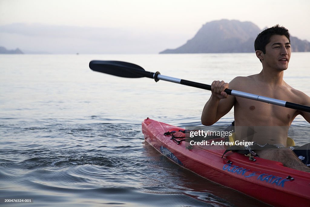 Young man kayaking in ocean