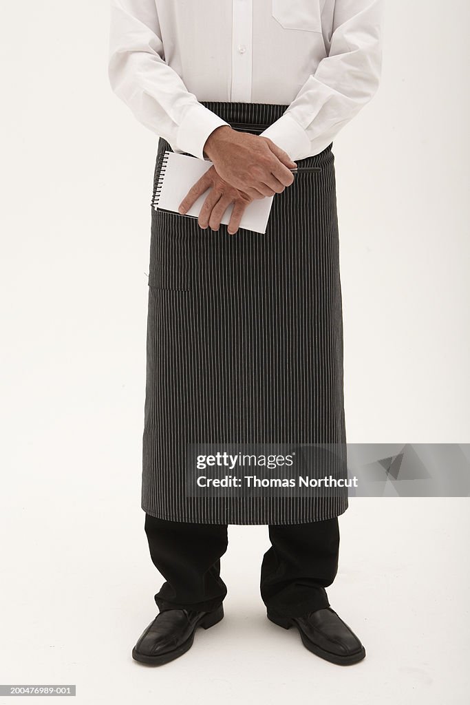 Waiter holding pen and notepad, low section