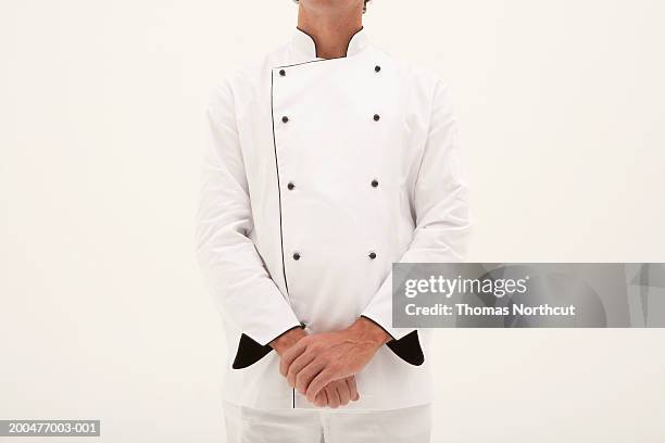 male chef standing with hands clasped, mid section - uniforme de chef fotografías e imágenes de stock