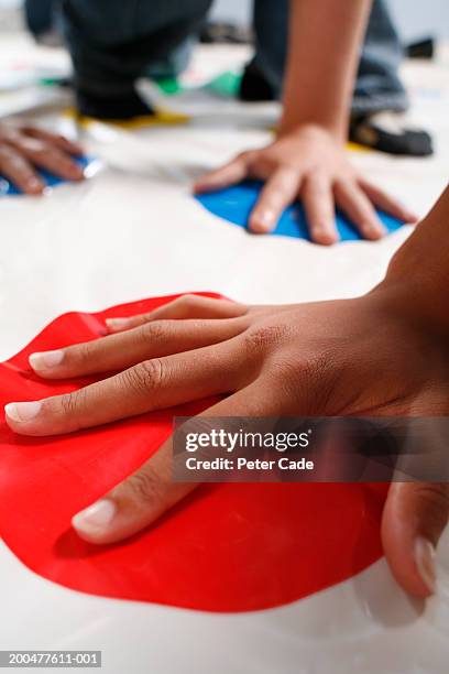 group of teenagers (16-19) playing floor game, close-up - twister stock-fotos und bilder