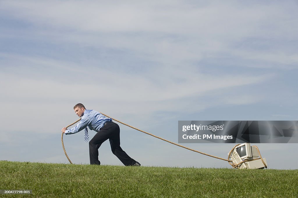 Businessman Dragging Old Computer Across Field With Rope Side View High ...