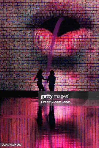 silhouette of two girls in front of crown fountain, dusk - millennium park chicago fotografías e imágenes de stock