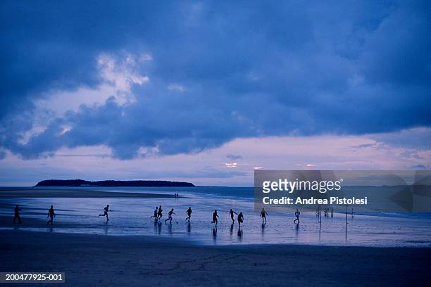 people playing football on beach, dusk - brazilian playing football stock pictures, royalty-free photos & images
