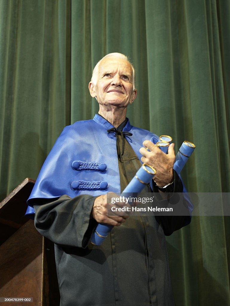 Dean holding diplomas