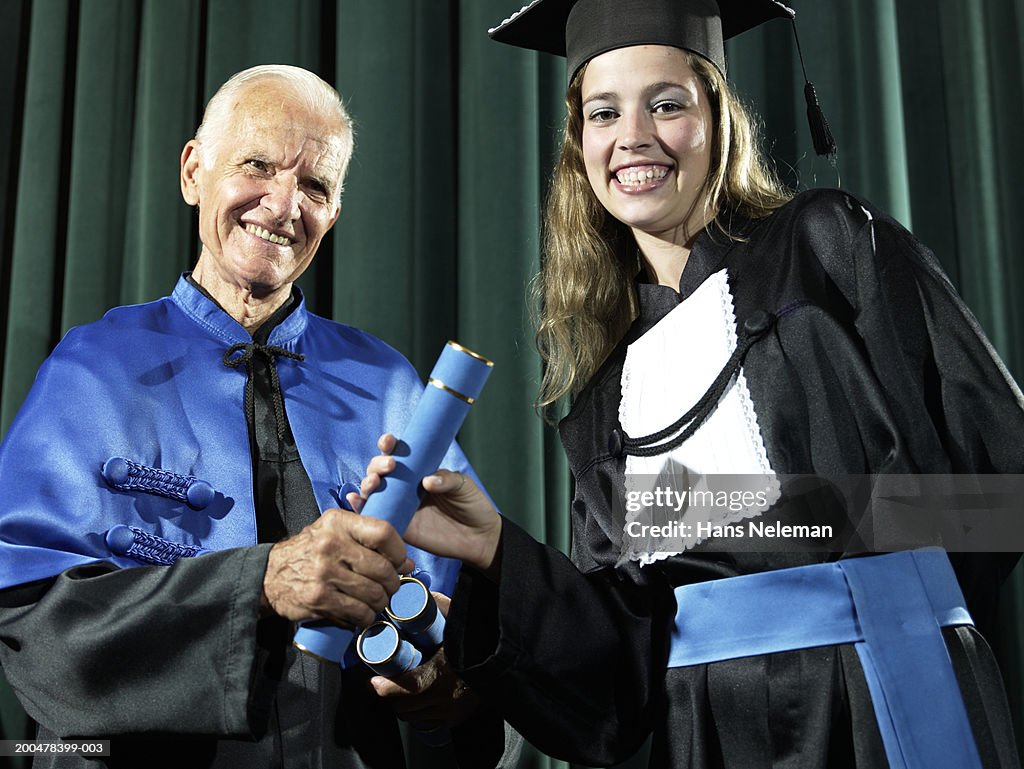 Dean awarding female graduate diploma