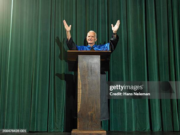 dean at lectern raising arms - dean stock pictures, royalty-free photos & images