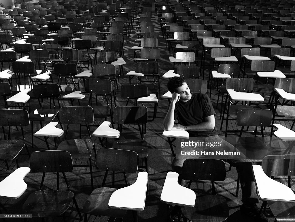 Student sitting at desk, looking to side (B&W)