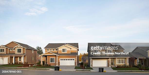 row of houses with garbage and recycling bins on roadside - residential building stock-fotos und bilder