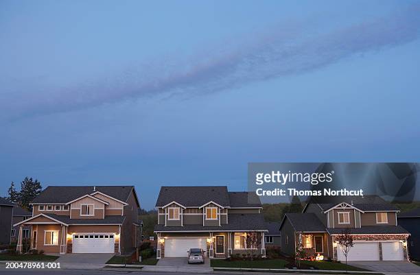 row of houses illuminated at dusk - imbrunire foto e immagini stock