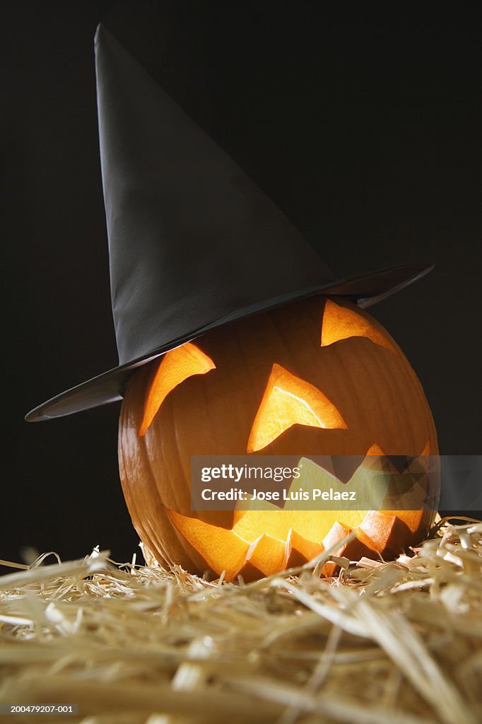 Jack o' lantern with witch's hat on hay bale