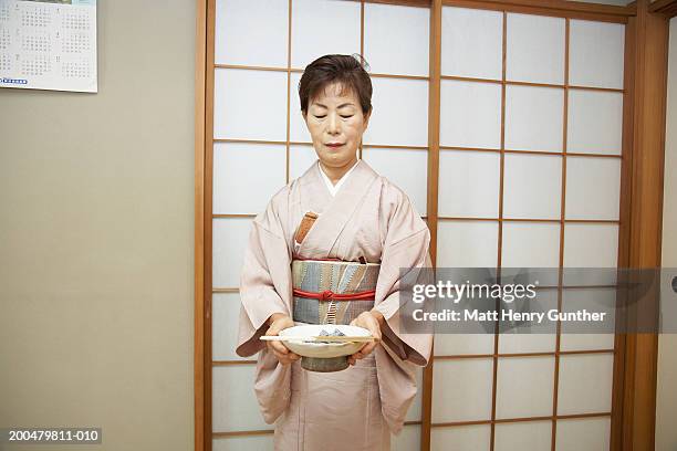 senior woman holdijng bowl at traditional tea service - kimono foto e immagini stock