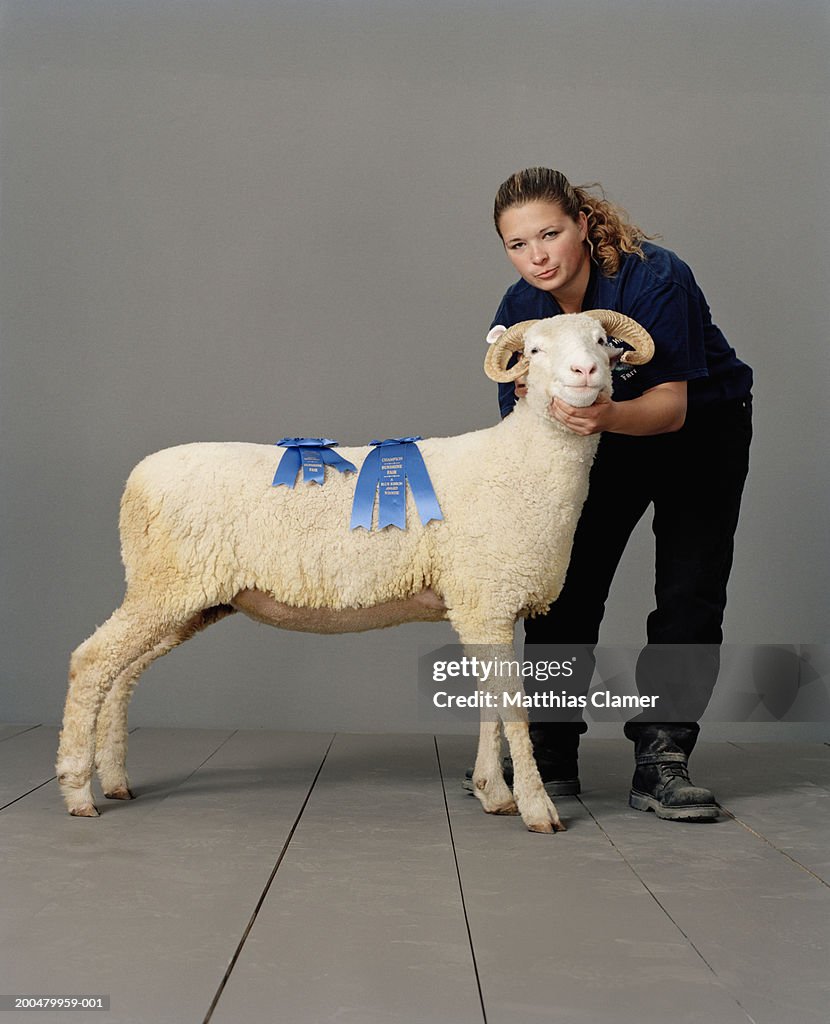 Teenage girl (17-19) with blue ribbon ram, portrait