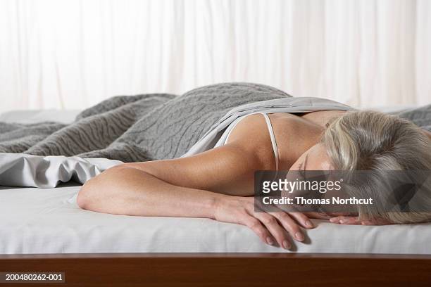 mature woman sleeping in bed - china foto e immagini stock
