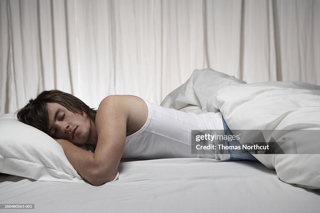 Young man sleeping in bed