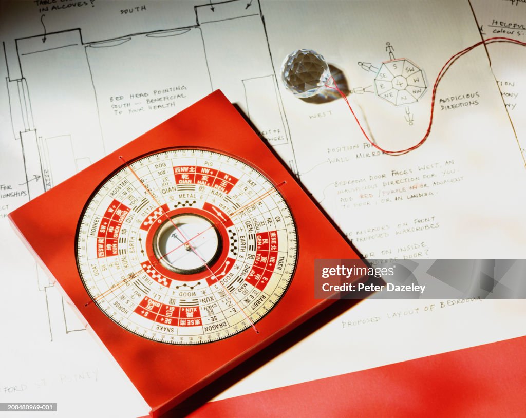 Feng shui compass and crystal on house plan, close-up, elevated view