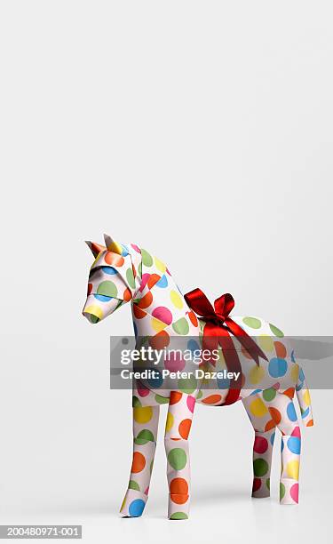 gift horse with ribbon against white background, close-up - horse studio stock-fotos und bilder