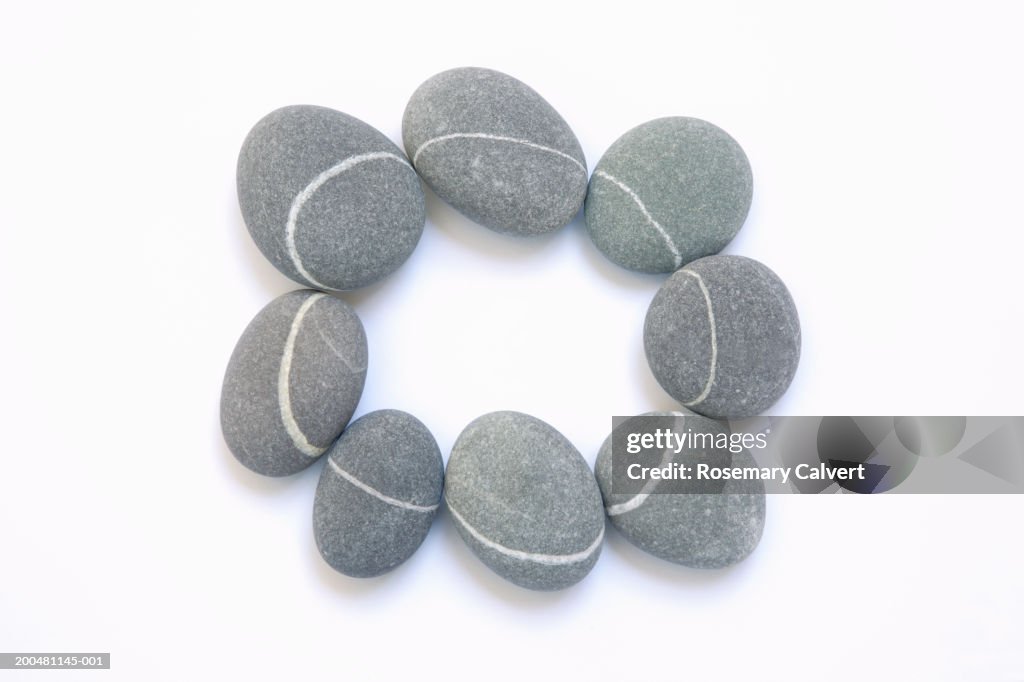 Granite pebbles with quartz veins forming circle, close-up