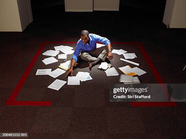 businessman sitting on floor with papers - job search stockfoto's en -beelden