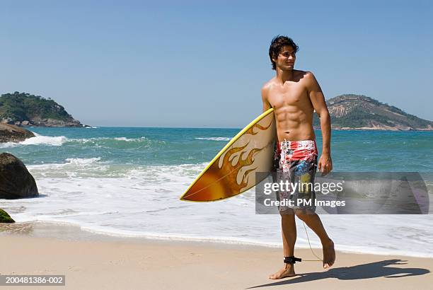 young man with surfboard walking on beach - beach holding surfboards stock pictures, royalty-free photos & images