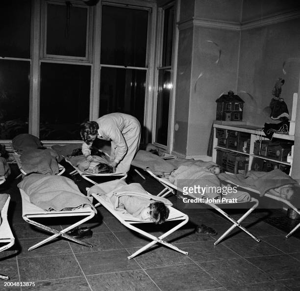 Children being tucked in for an afternoon nap at the Belgrave Mills' day nursery in Oldham, November 1955. Cotton mills in the region set up their...