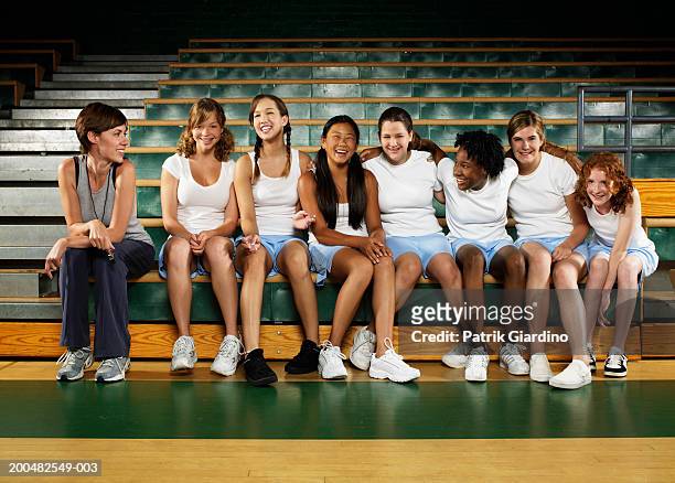 teenage girls (12-16) with instructor in gym class, smiling - girl who stands stock pictures, royalty-free photos & images