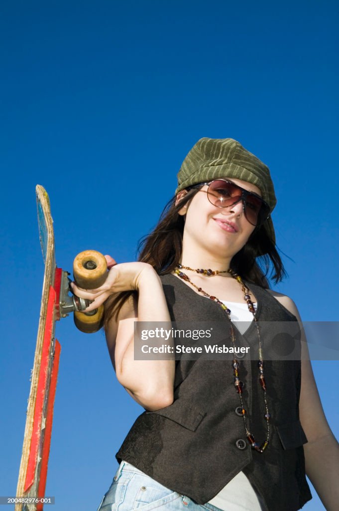 Teenage girl (16-18) with skateboard