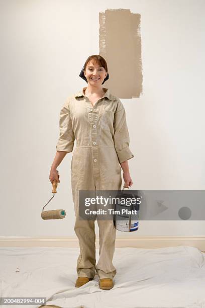 woman in overalls holding paint can and roller, portrait - holding paint roller stock pictures, royalty-free photos & images