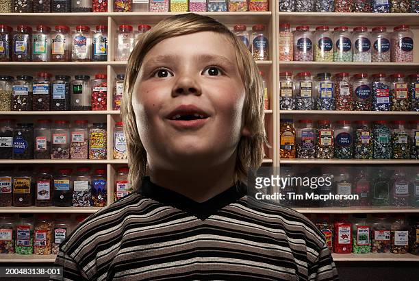 boy (6-8) in sweetshop, close-up (digital composite) - imponente fotografías e imágenes de stock