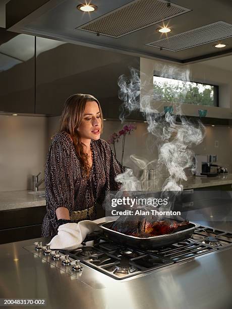 woman looking at burnt turkey in kitchen - burnt chicken stock pictures, royalty-free photos & images