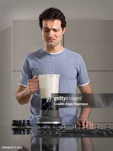 man splashed by smoothie from blender in kitchen - mixer stock-fotos und bilder