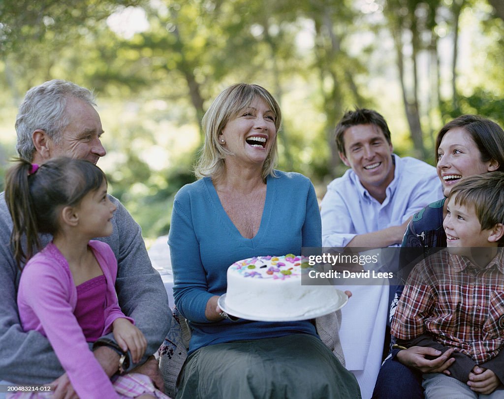 Three generation family with two children (6-7, 8-9) celebrating birthday in garden