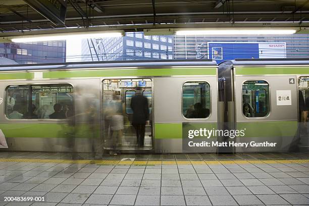 japan, tokyo, commuters boarding train (long exposure) - binario di stazione ferroviaria foto e immagini stock