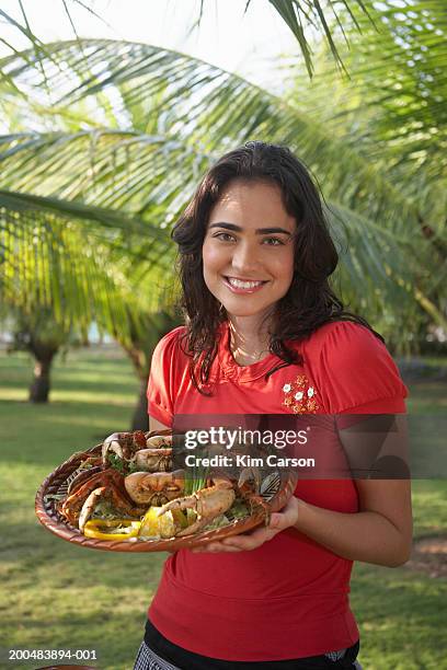 young woman holding platter of cooked crab, portrait - estado do ceará brasil imagens e fotografias de stock