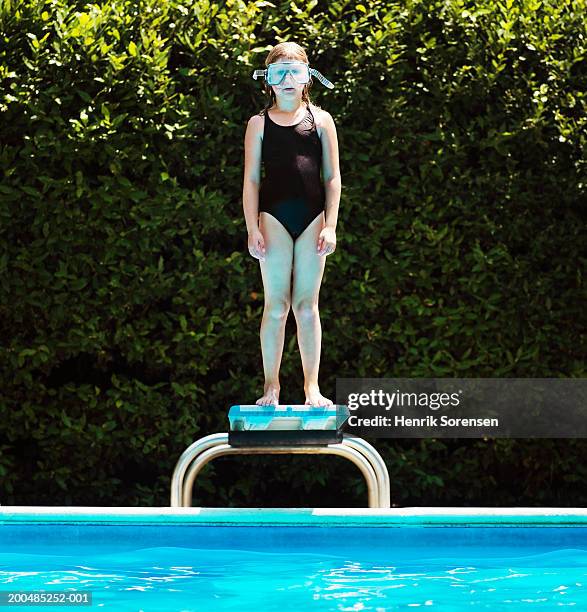 girl (7-9) in scuba mask standing on springboard beside pool - diving board stock pictures, royalty-free photos & images