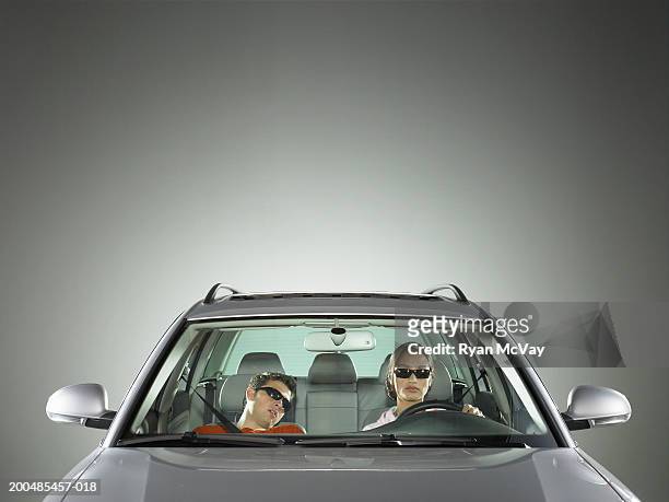 young man and woman in car, woman driving while man sleeps - punto di vista frontale foto e immagini stock