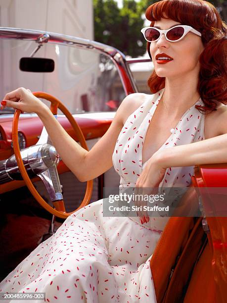 woman in 50's style dress  sitting in vintage car - 1950s fashion stock pictures, royalty-free photos & images