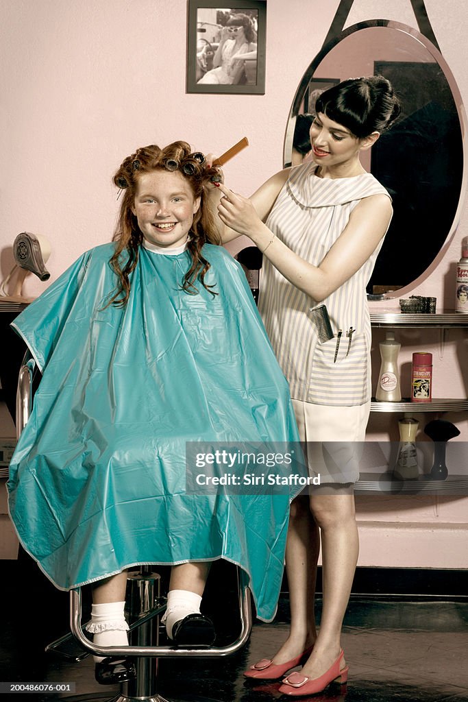 Girl (10-12) having hair styled in beauty salon