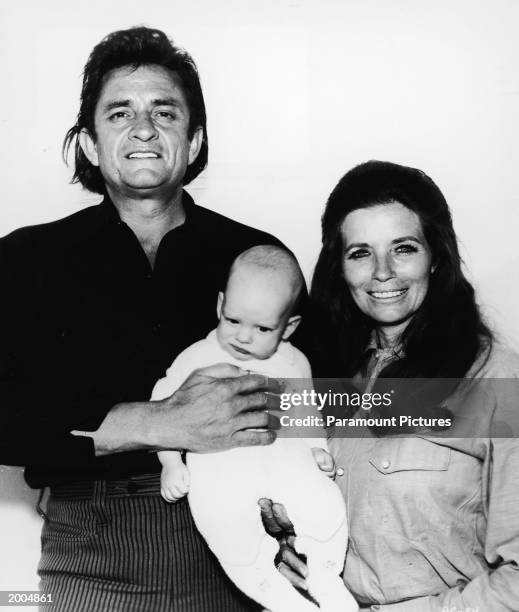 American country musicians Johnny Cash and his wife June Carter Cash with their infant son John Carter Cash in a promotional portrait for the film 'A...