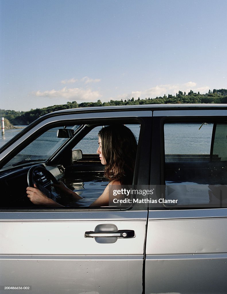 Woman in car filled with water, side view