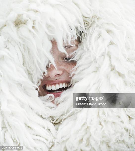 young woman wrapped in wool blanket, eyes closed, laughing, close-up - wrapped in a blanket stockfoto's en -beelden