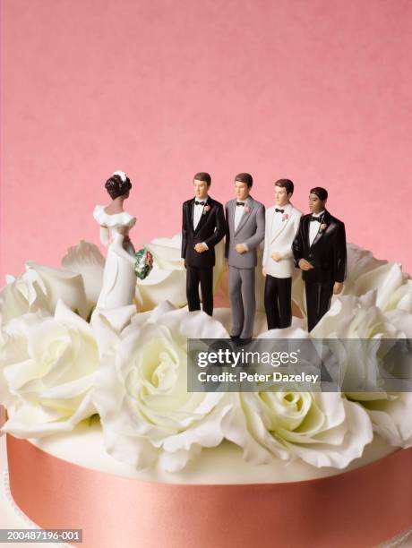 bride figure on wedding cake with a choice of four grooms - polygamie stock-fotos und bilder