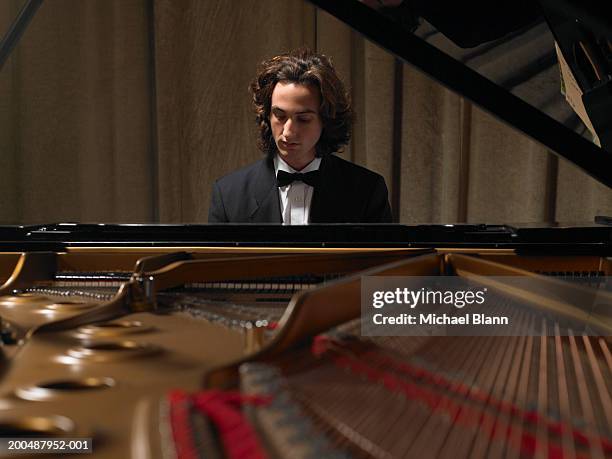 concert pianist playing grand piano - man playing piano stock pictures, royalty-free photos & images