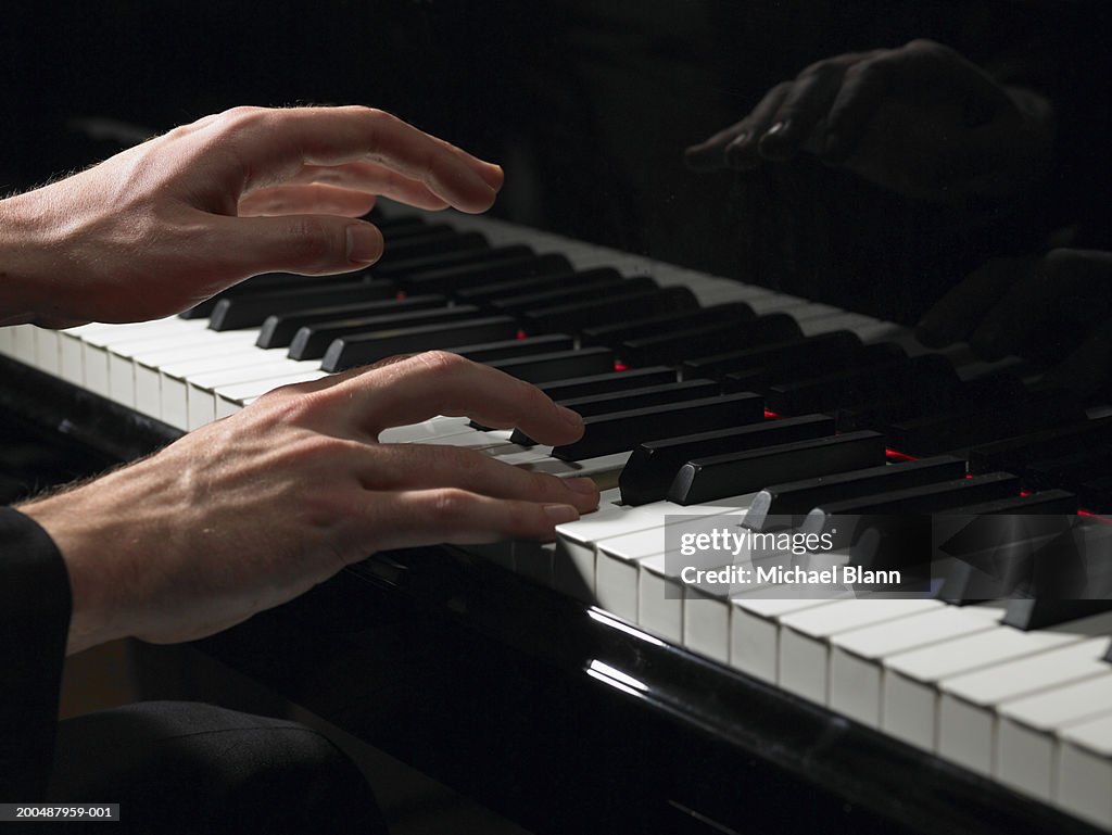 Male pianist playing piano, close-up