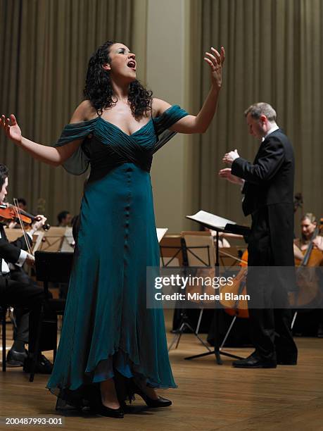 female singer performing with orchestra - orchestra stock-fotos und bilder