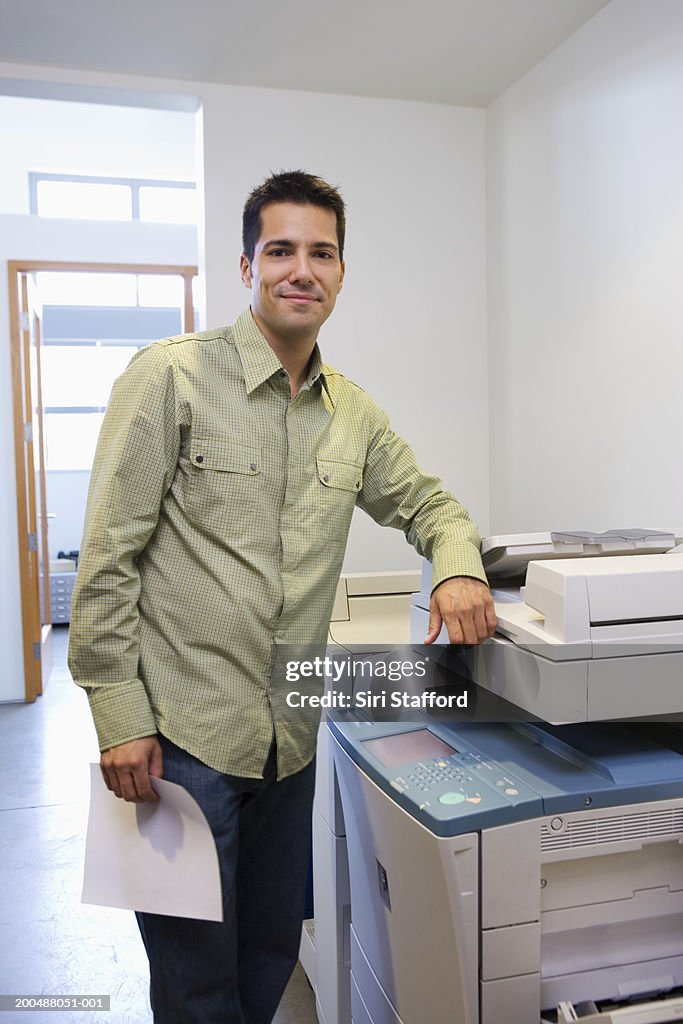Businessman standing by  copy machine in office