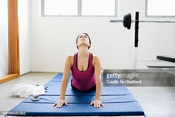 young woman doing yoga on mat in gym - cabeça para trás - fotografias e filmes do acervo