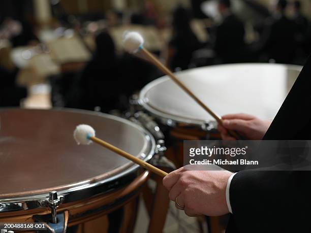 male timpanist playing kettledrums in orchestra, close-up - orchester stock-fotos und bilder